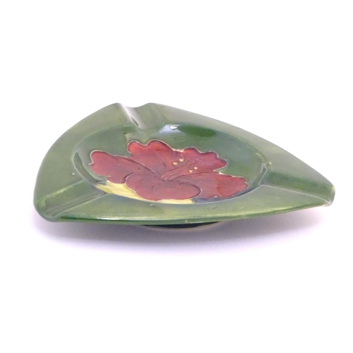 111 - A Moorcroft green ground pin dish / ashtray of triangular form in the Hibiscus pattern. Impressed ma... 