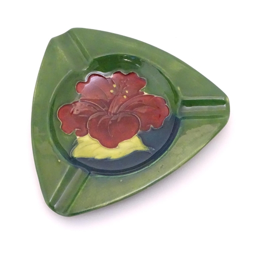 111 - A Moorcroft green ground pin dish / ashtray of triangular form in the Hibiscus pattern. Impressed ma... 