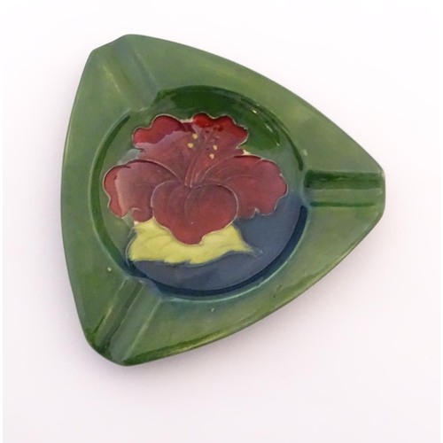 111 - A Moorcroft green ground pin dish / ashtray of triangular form in the Hibiscus pattern. Impressed ma... 