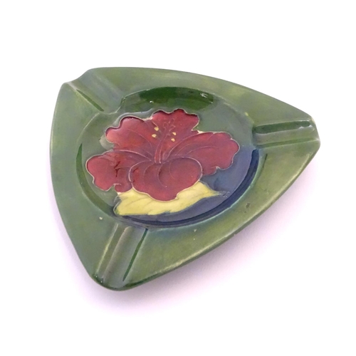 111 - A Moorcroft green ground pin dish / ashtray of triangular form in the Hibiscus pattern. Impressed ma... 