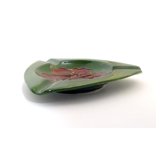 111 - A Moorcroft green ground pin dish / ashtray of triangular form in the Hibiscus pattern. Impressed ma... 