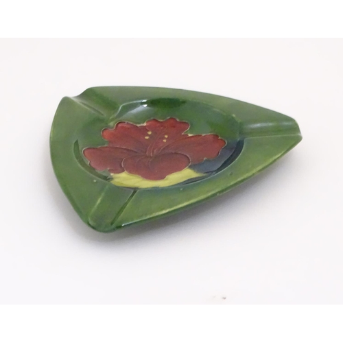 111 - A Moorcroft green ground pin dish / ashtray of triangular form in the Hibiscus pattern. Impressed ma... 