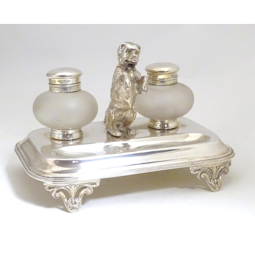 1007 - A silver plate desk standish with two glass inkwells and a model of a begging dog to centre. Approx.... 