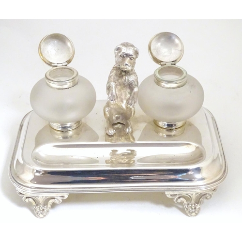 1007 - A silver plate desk standish with two glass inkwells and a model of a begging dog to centre. Approx.... 