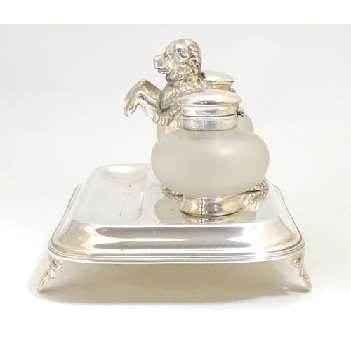 1007 - A silver plate desk standish with two glass inkwells and a model of a begging dog to centre. Approx.... 