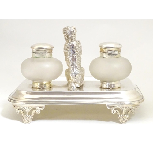 1007 - A silver plate desk standish with two glass inkwells and a model of a begging dog to centre. Approx.... 