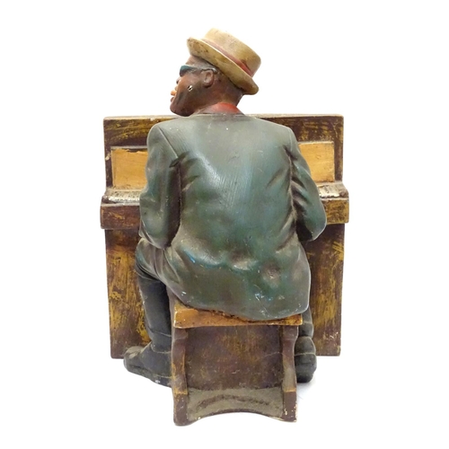 1013 - A 20thC model of a black gentleman playing the piano, possibly Ray Charles. Approx. 15 1/2