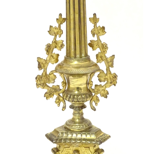 1031 - A 20thC large ecclesiastical gilded pricket candlestick with a fluted column flanked by applied vine... 