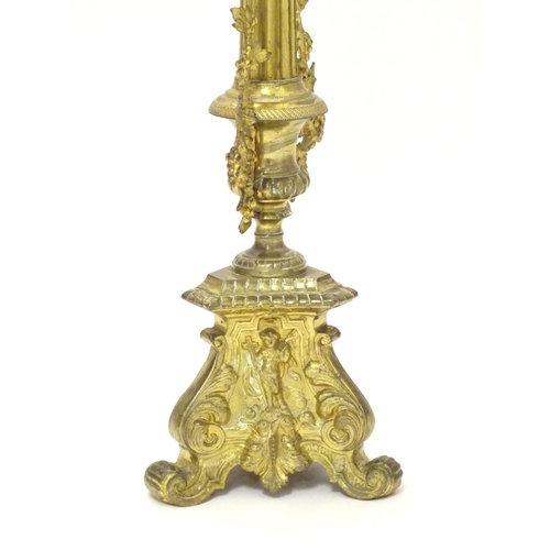 1031 - A 20thC large ecclesiastical gilded pricket candlestick with a fluted column flanked by applied vine... 