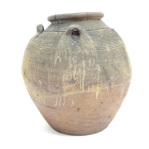 1086 - An antique clay pot / vase with loop handles and incised banded detail. Approx. 14 1/2