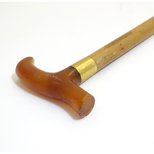 1093 - An early to mid-20thC Brigg walking stick, with 18ct gold band, amber Bakelite handle, malacca shaft... 