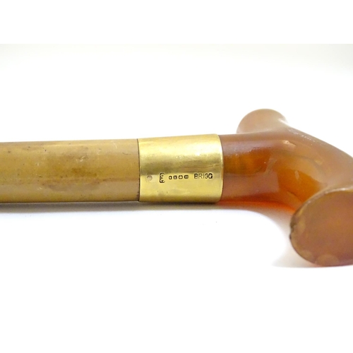 1093 - An early to mid-20thC Brigg walking stick, with 18ct gold band, amber Bakelite handle, malacca shaft... 