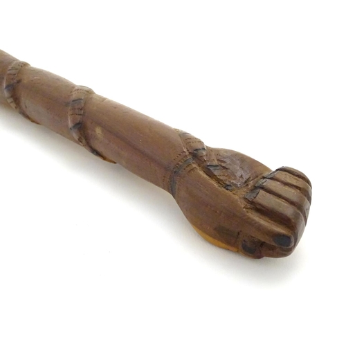 1094 - An early 20thC Australian blackwood walking cane, the knop formed as a clenched fist holding a snake... 