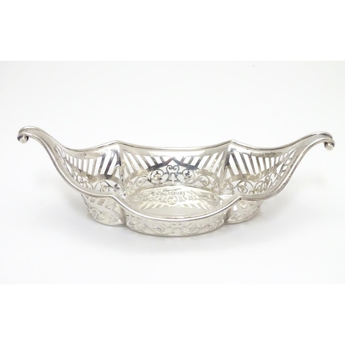 194 - A Silver boat-shaped dish with scroll ends and pierced decoration. Bears a small yacht style mark un... 