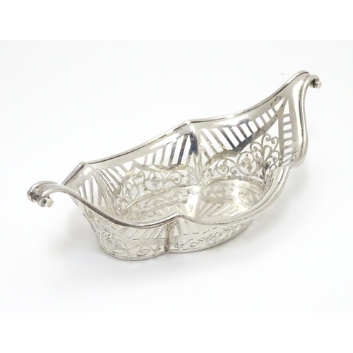 194 - A Silver boat-shaped dish with scroll ends and pierced decoration. Bears a small yacht style mark un... 