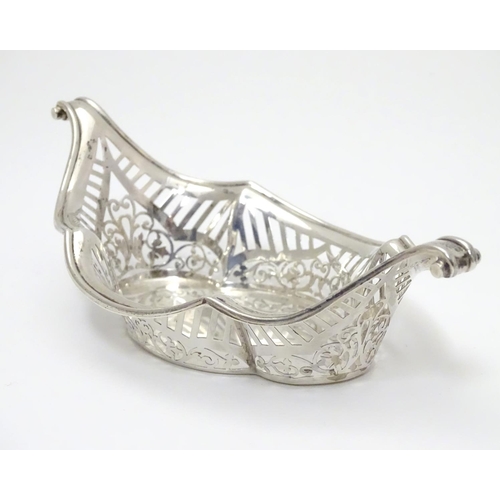 194 - A Silver boat-shaped dish with scroll ends and pierced decoration. Bears a small yacht style mark un... 