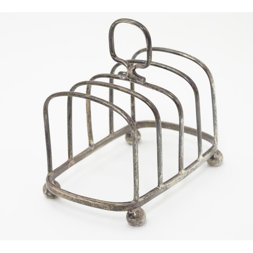 196 - A Silver four division toast rack raised on four bun feet. Hallmarked Birmingham 1923 maker Haseler ... 