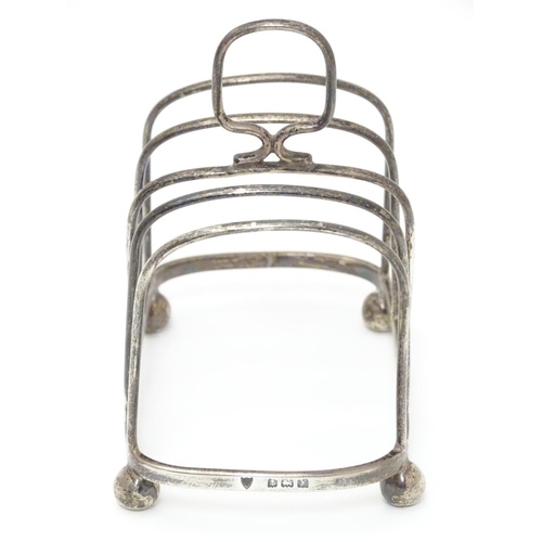 196 - A Silver four division toast rack raised on four bun feet. Hallmarked Birmingham 1923 maker Haseler ... 