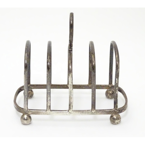 196 - A Silver four division toast rack raised on four bun feet. Hallmarked Birmingham 1923 maker Haseler ... 