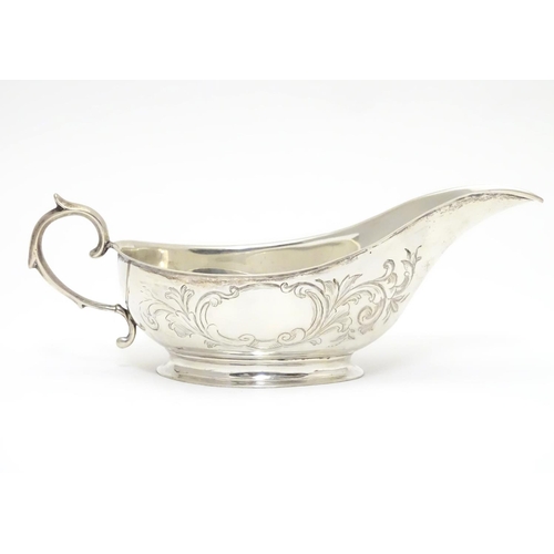 197 - An American Mid 19thC white metal sauce boat with engraved floral and foliate decoration. Bears make... 