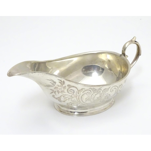 197 - An American Mid 19thC white metal sauce boat with engraved floral and foliate decoration. Bears make... 