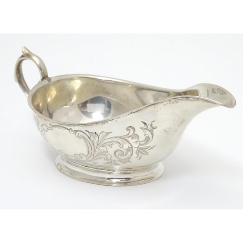 197 - An American Mid 19thC white metal sauce boat with engraved floral and foliate decoration. Bears make... 