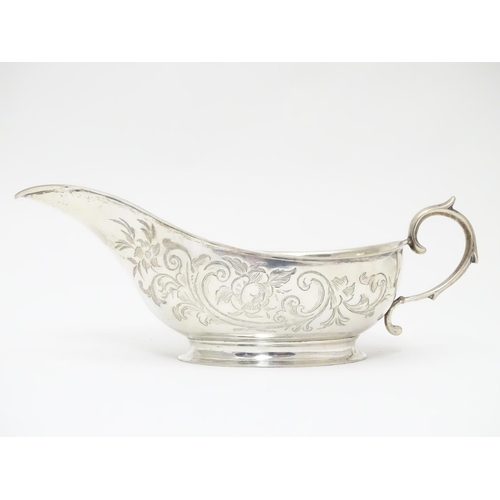 197 - An American Mid 19thC white metal sauce boat with engraved floral and foliate decoration. Bears make... 