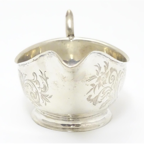 197 - An American Mid 19thC white metal sauce boat with engraved floral and foliate decoration. Bears make... 