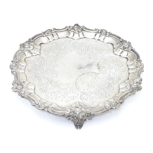 293 - A Victorian silver salver with engraved decoration and on three scrolled feet. Hallmarked London 184... 