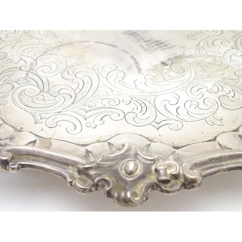 293 - A Victorian silver salver with engraved decoration and on three scrolled feet. Hallmarked London 184... 