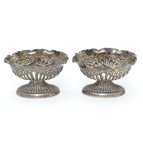 296 - A pair of Victorian silver table salts with fluted decoration and wavy rims, raised on oval pedestal... 