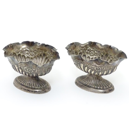 296 - A pair of Victorian silver table salts with fluted decoration and wavy rims, raised on oval pedestal... 