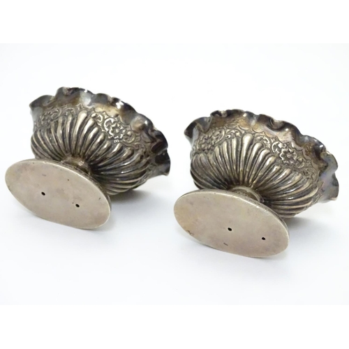 296 - A pair of Victorian silver table salts with fluted decoration and wavy rims, raised on oval pedestal... 