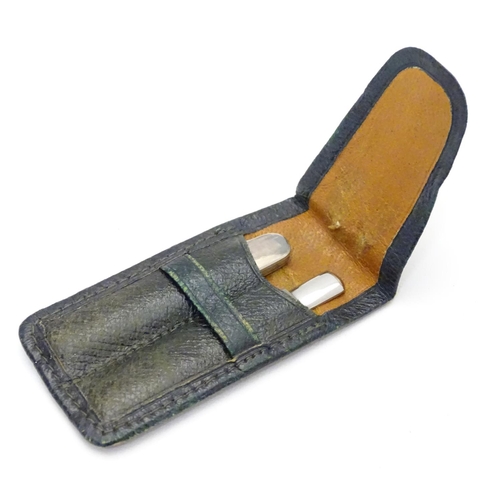 299 - A green leather pouch containing a file and folding twin blade knife, marked 'Silver'. The case 23/4... 