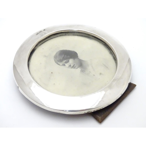 303 - A photograph frame of circular form with silver surround. Hallmarked Birmingham 1916 maker William N... 