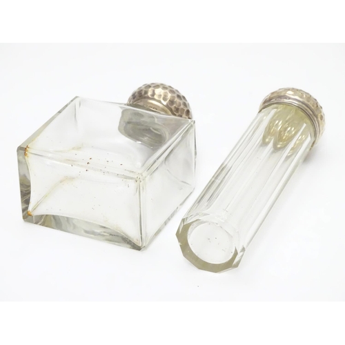 306 - A silver lidded glass scent bottle and a matching silver lidded glass vanity bottle, both lids with ... 