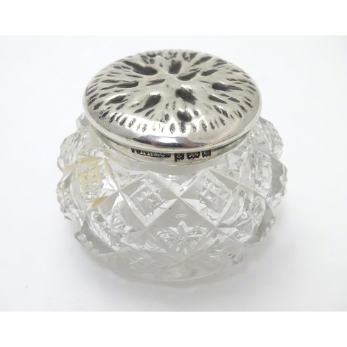 309 - A cut glass pot with silver lid with textured decoration to top. Hallmarked Birmingham 1902 maker T ... 