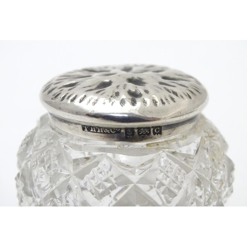 309 - A cut glass pot with silver lid with textured decoration to top. Hallmarked Birmingham 1902 maker T ... 