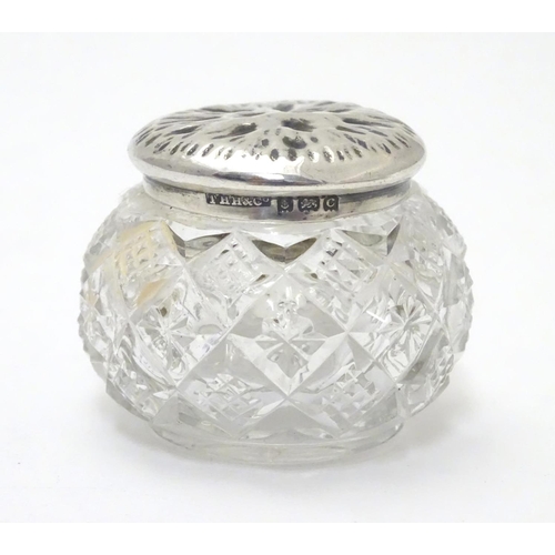 309 - A cut glass pot with silver lid with textured decoration to top. Hallmarked Birmingham 1902 maker T ... 