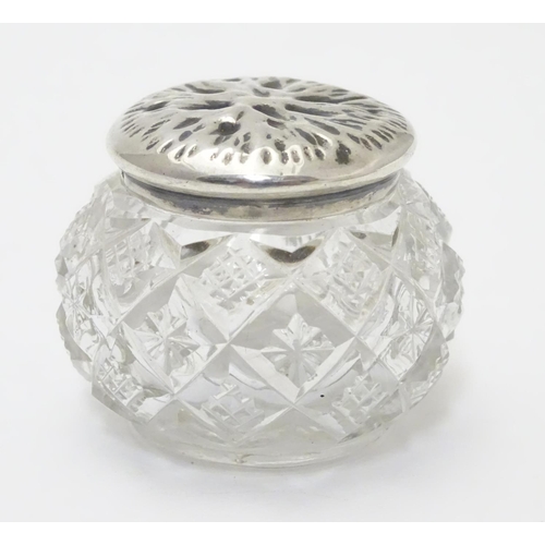 309 - A cut glass pot with silver lid with textured decoration to top. Hallmarked Birmingham 1902 maker T ... 