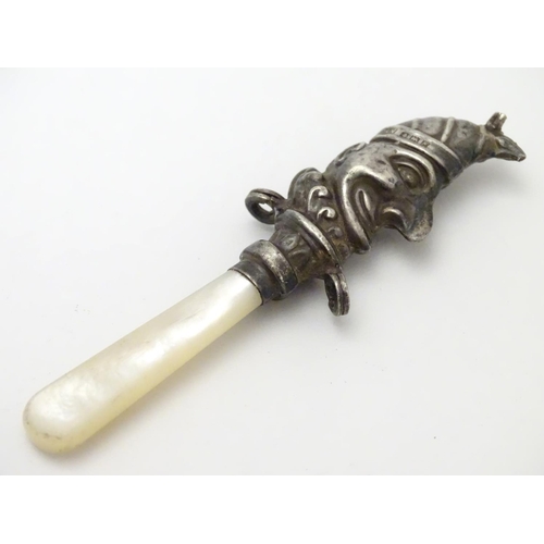 310 - A child's rattle with mother of pearl teether and silver Mr Punch decoration. Hallmarked Birmingham ... 