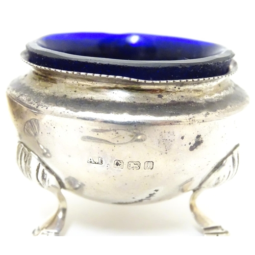 312 - A pair of circular silver table salts, each raised on three hoof feet, with blue glass liners and ma... 