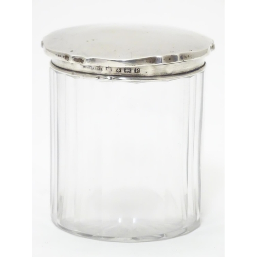 319 - A glass jar with silver lid hallmarked Birmingham 1914 3 1/4