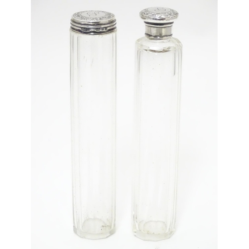 329 - Two glass dressing table bottles with silver tops hallmarked London 1895. The tallest 7