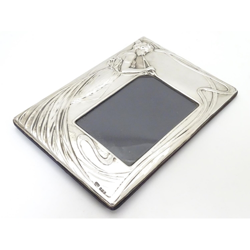 424 - A photograph frame with silver surround with Art Nouveau style decoration. Hallmarked Birmingham 198... 