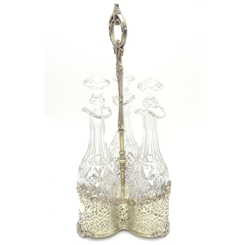 426 - A Victorian silver plate tantalus / bottle stand with three cut glass decanters. The whole approx 19... 