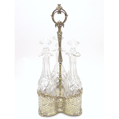 426 - A Victorian silver plate tantalus / bottle stand with three cut glass decanters. The whole approx 19... 