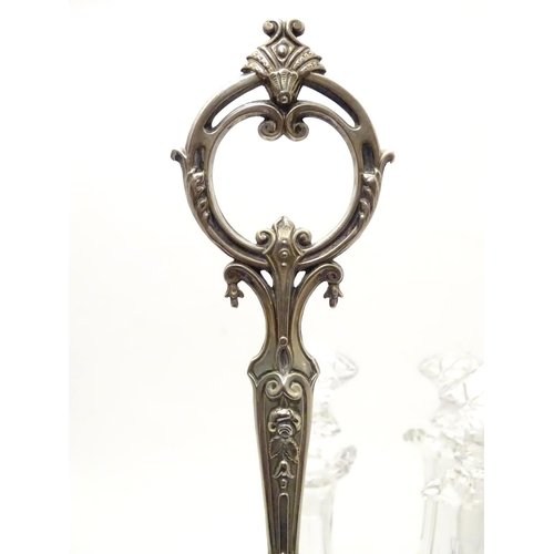 426 - A Victorian silver plate tantalus / bottle stand with three cut glass decanters. The whole approx 19... 