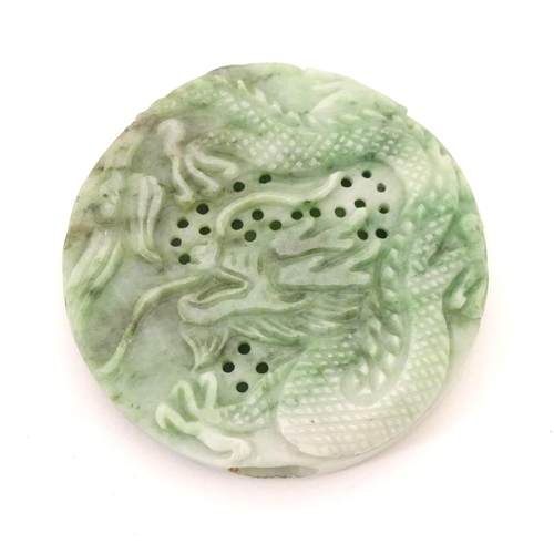 846 - An Oriental jade roundel carving depicting a stylised dragon. Approx. 2 1/4