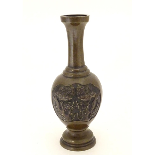 847 - An Oriental bronze vase of baluster form with a stepped base and neck, the body with cast vignettes ... 